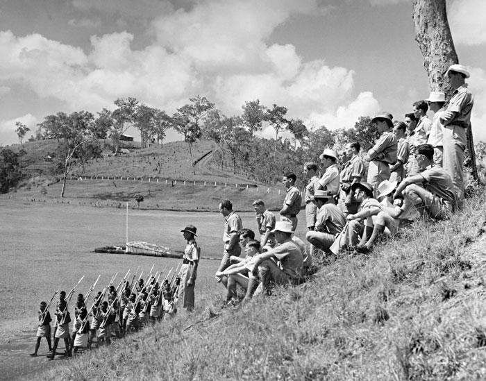 HistPOM-27-1950.jpg - A new batch of Cadet Patrol Officers being shown over the Royal Papuan Constabulary police barracks at Sogeri, in the hills back of Port Moresby - Here they see a platoon of native police march past in fatigue dress – 1950; Photographer: William (Bill) Brindle (source: Natioal Archives of Australia; http://www.naa.gov.au/collection/snapshots/on-patrol-in-papua-new-guinea/sogeri-barracks.aspx; accessed: 4.2.2013)